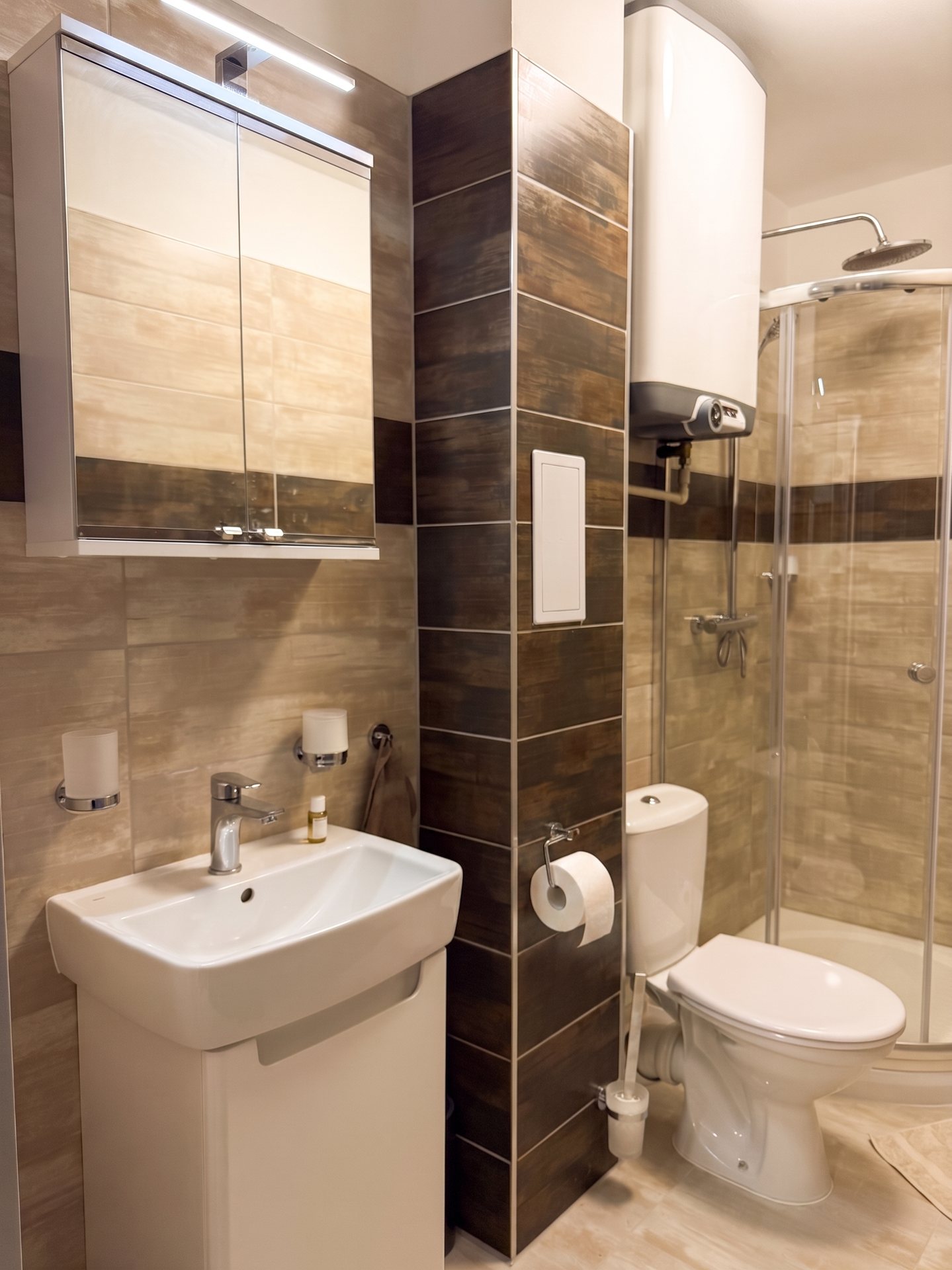 Moderní koupelna s proskleným sprchovým koutem a zrcadlem – Apartmány Panorama
