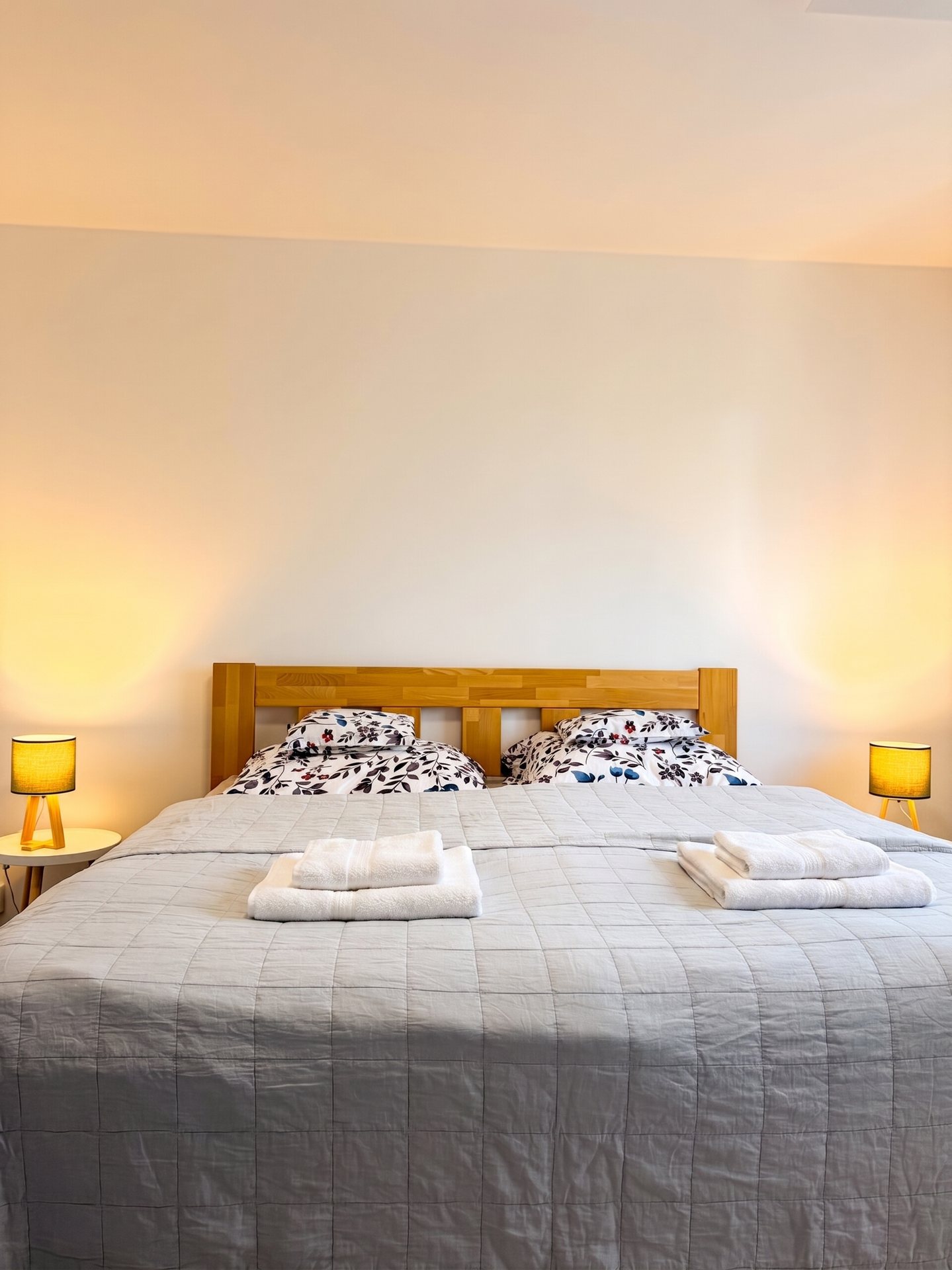 Ložnice s manželskou postelí z masivu a lampičkami – Apartmány Panorama Bublava
